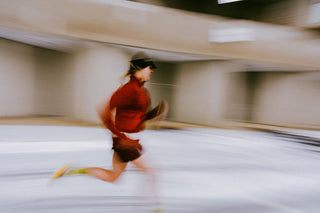 Two runners resting after an effort, both in running caps